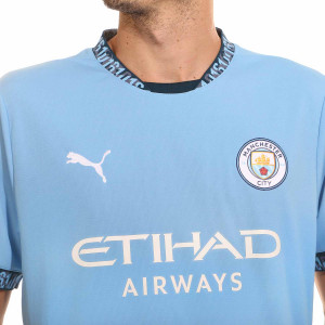 /7/7/775075-01-17DBRYN.A_camiseta-puma-manchester-city-de-bruyne-2024-2025-pl-color-azul_3_detalle-cuello-y-pecho-con-escudo.jpg